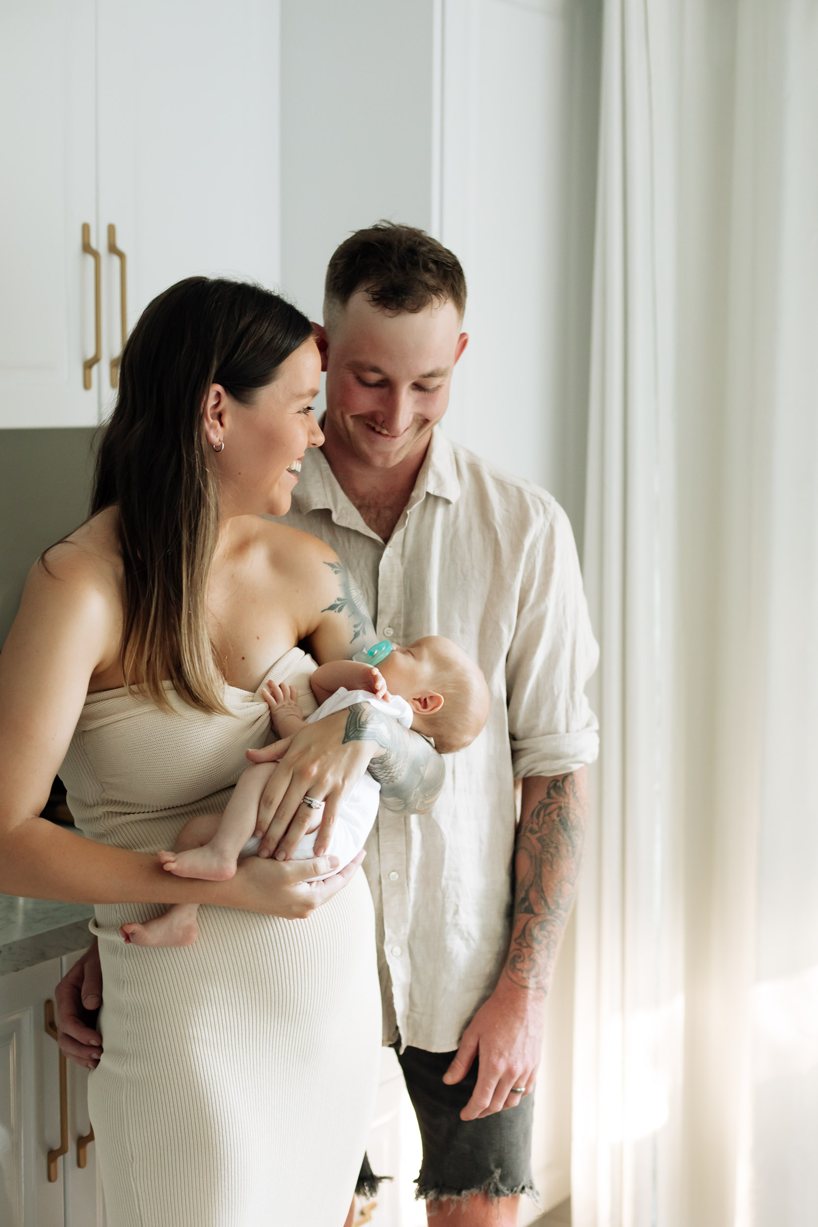 Parents holding newborn baby in home in Mackay