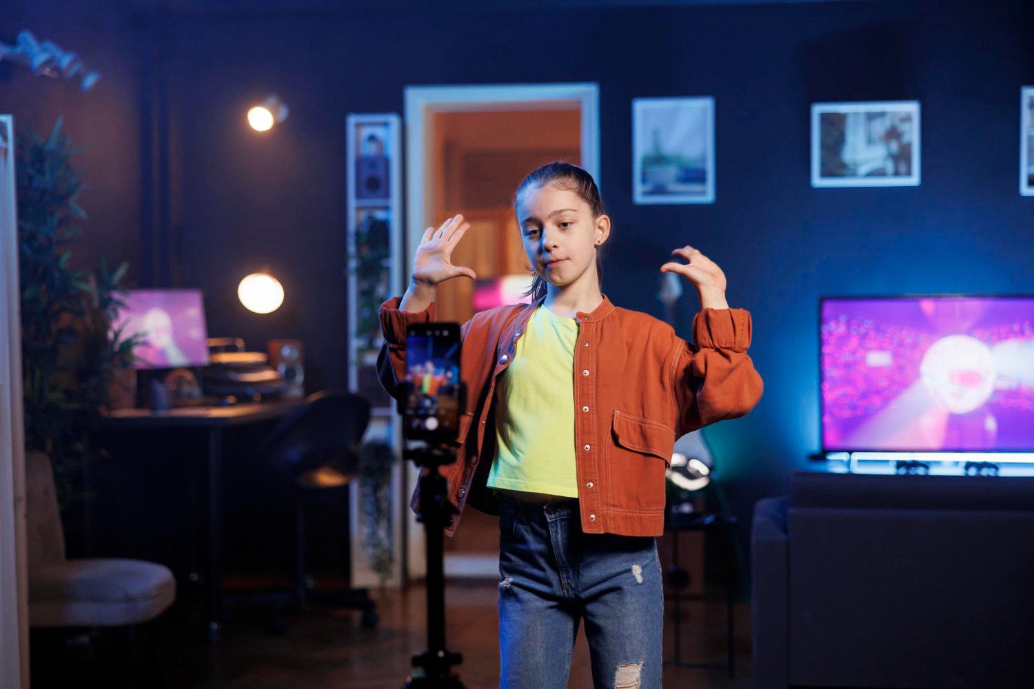 A young girl stands in front of a television, gazing attentively at the screen with a curious expression.