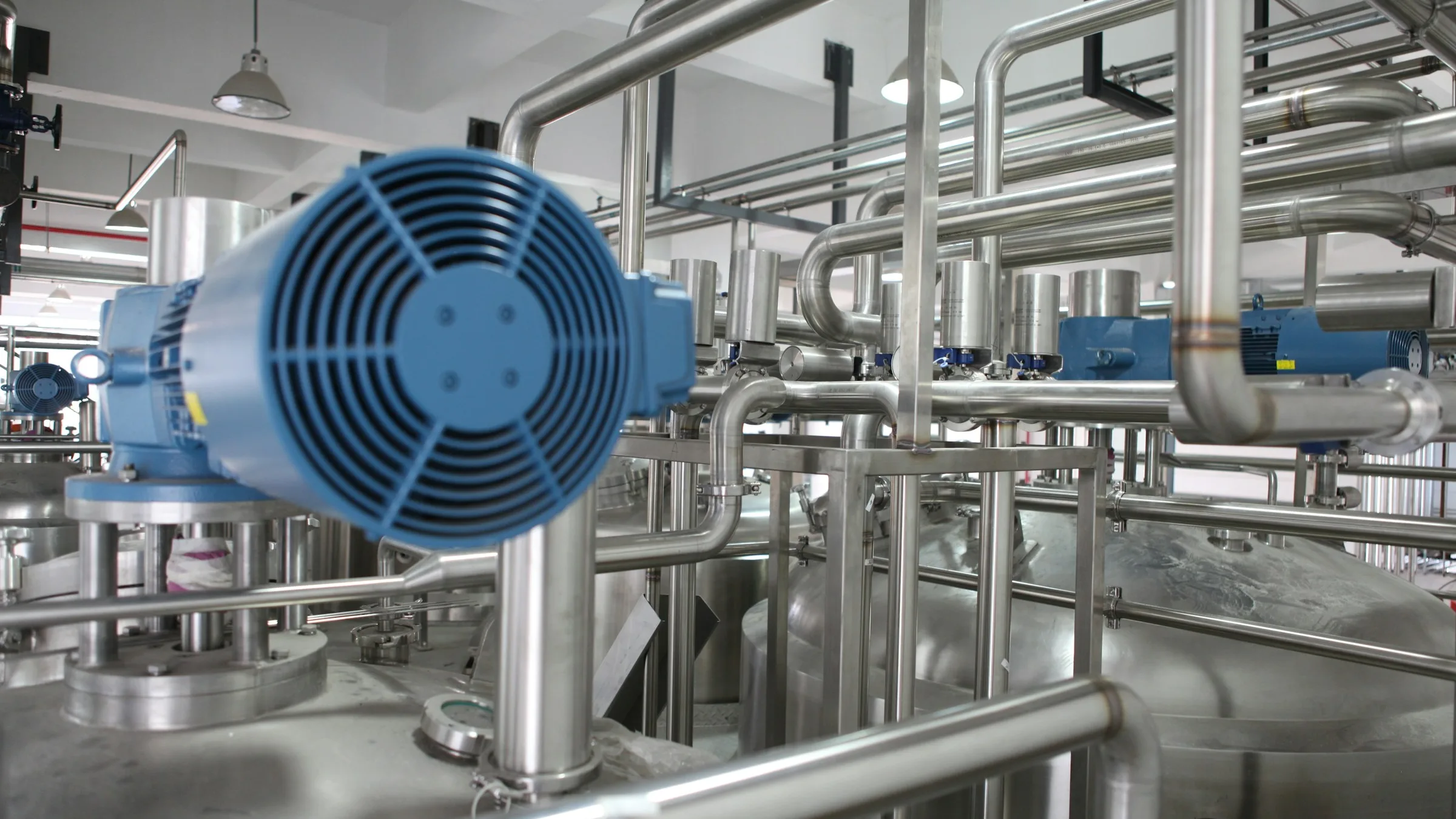 Stainless steel process piping and pumps inside a modern industrial plant