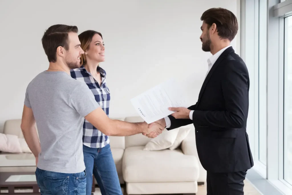 Landlord property management app represented by a couple shaking hands with a property manager holding a contract.