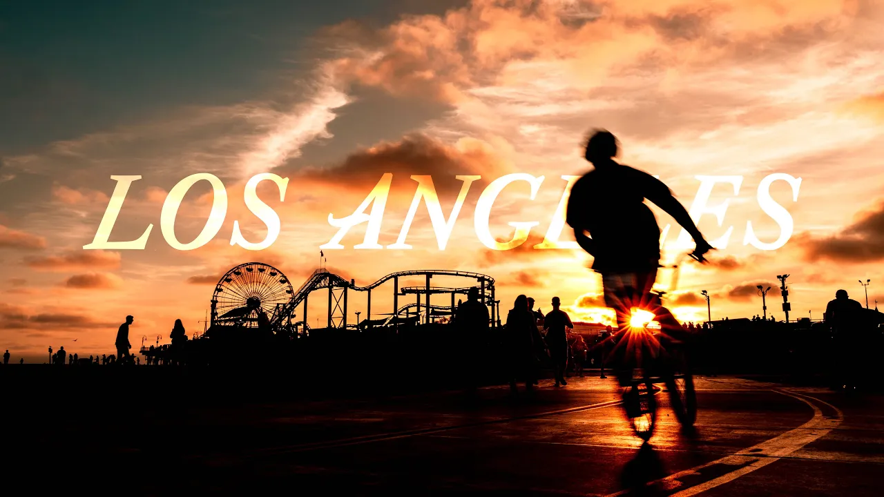 Coucher de soleil à Santa Monica avec un cycliste en silhouette devant une fête foraine.