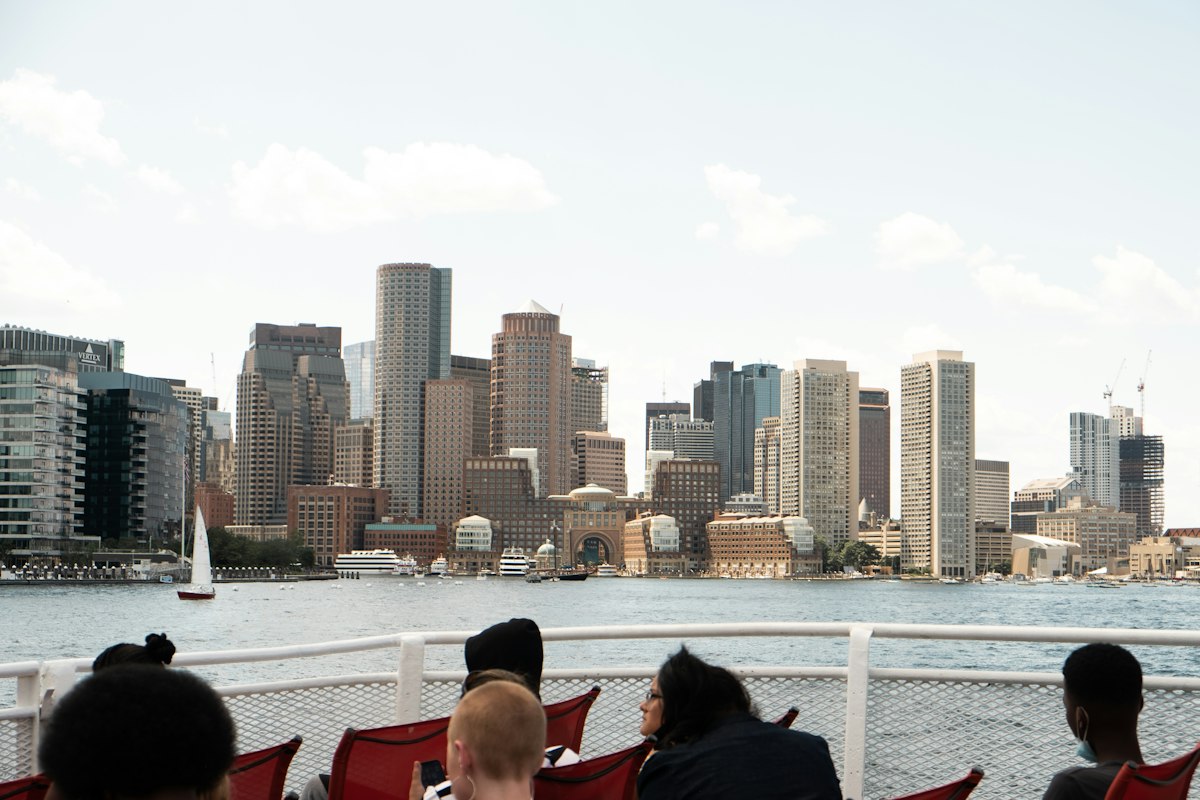 Passengers sitting on the open top deck of a harbor ferry