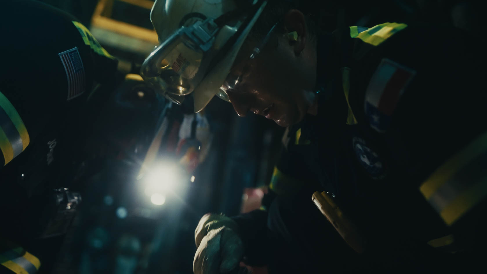 Elegant hand against a red background wearing two gold bracelets, one sleek and minimal, the other a delicate chain.