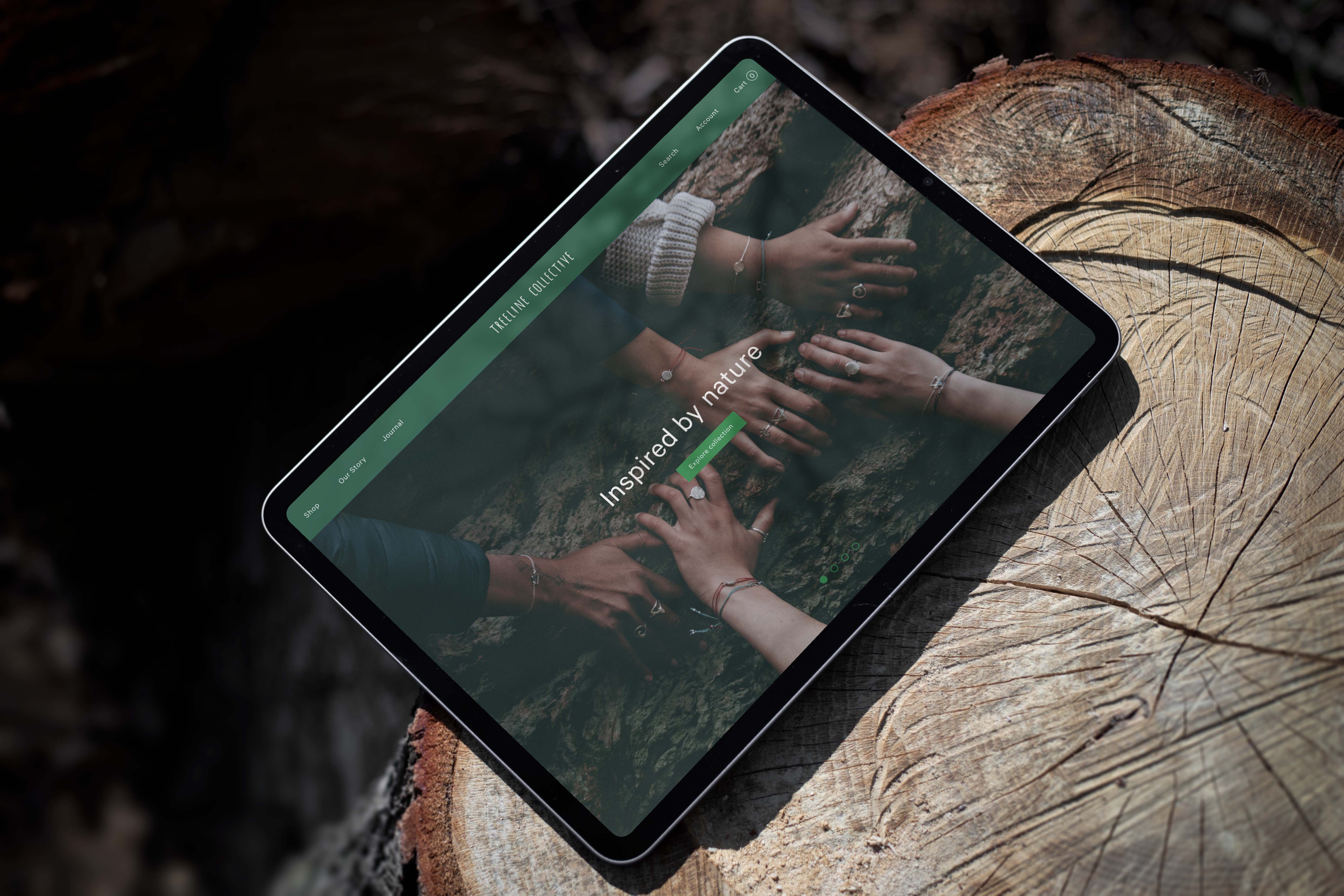 Ipad resting on a tree stump displaying the Treeline Collective's homepage