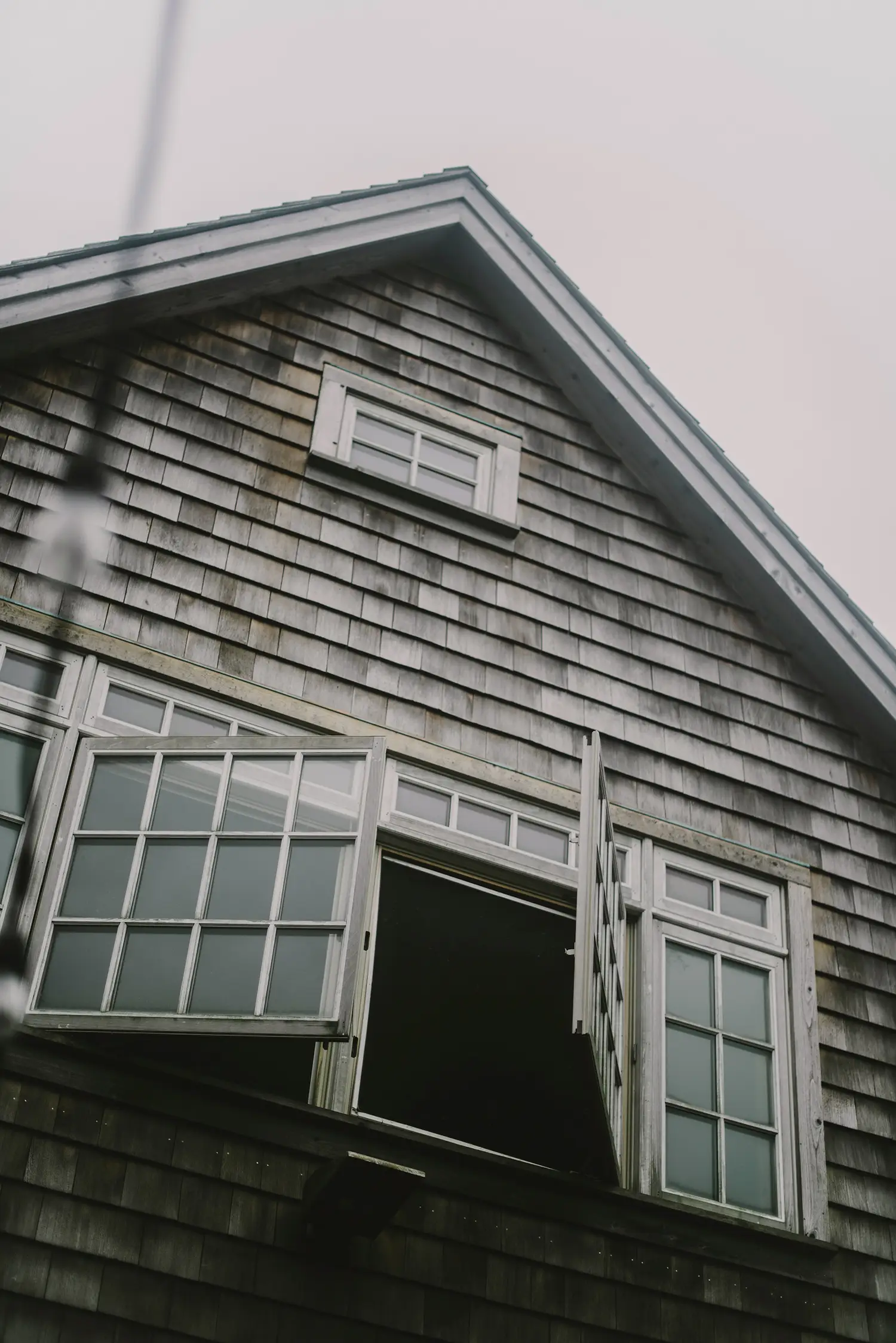 A quintessential cedar shingled summer house in The Hamptons with open windows