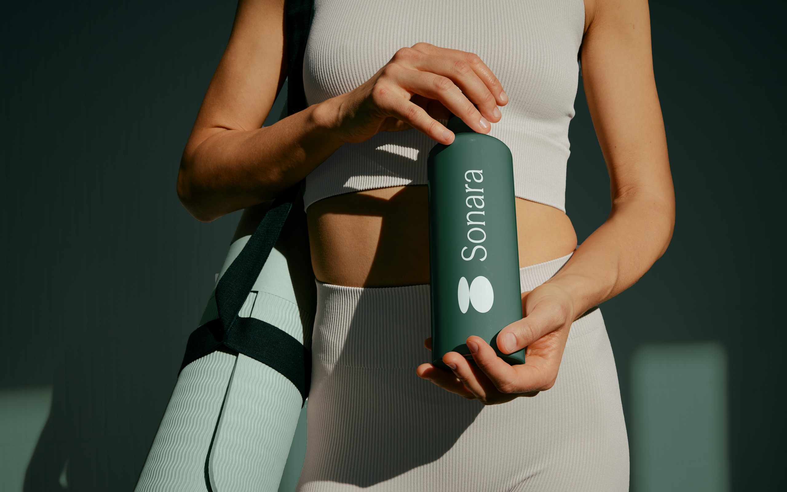 Woman with yoga mat and drinking bottle