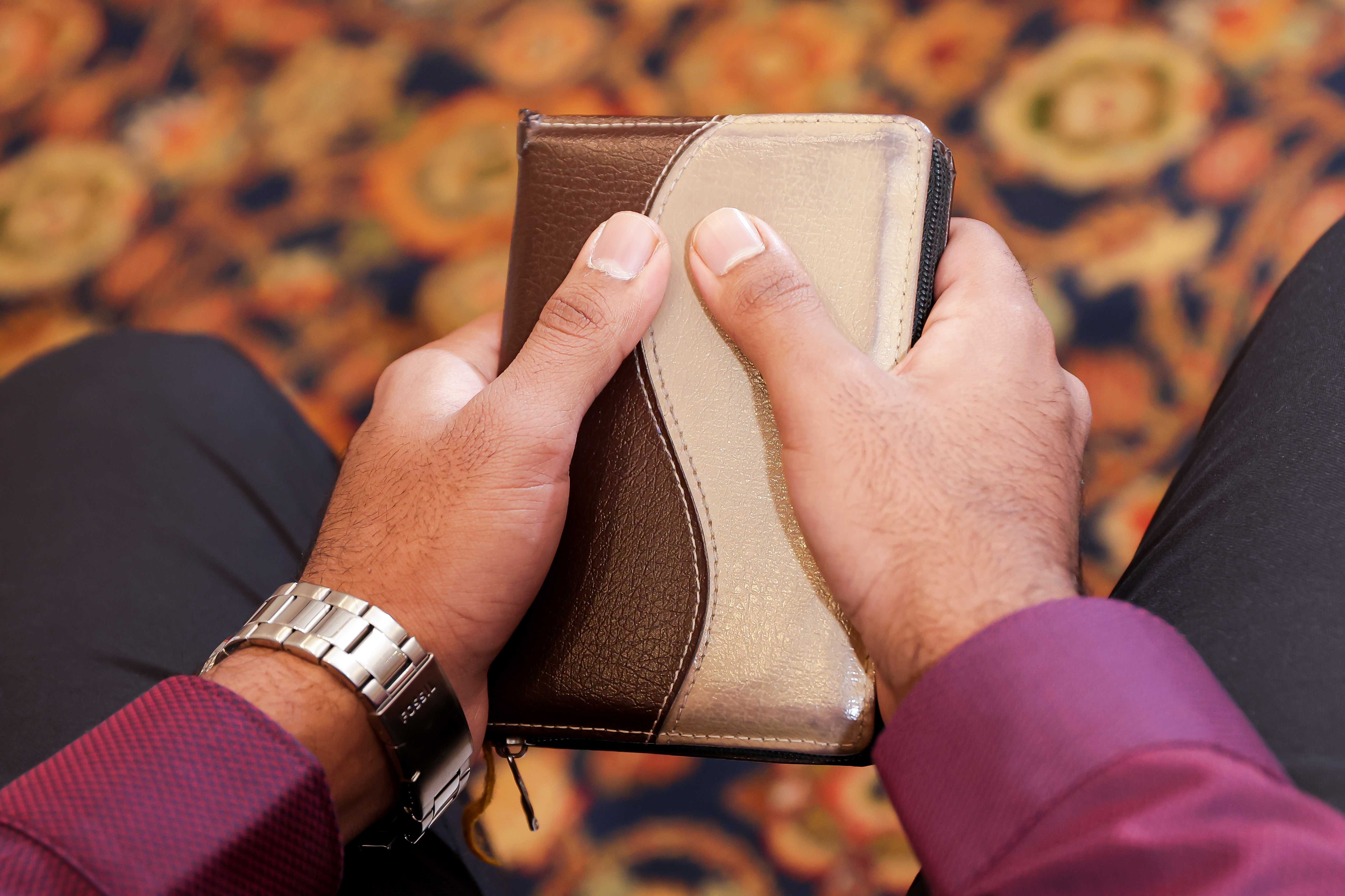 A woman with long blonde hair, in a brown top and jeans, walks through a sunlit forest, holding someone's hand. The scene is warm and inviting.