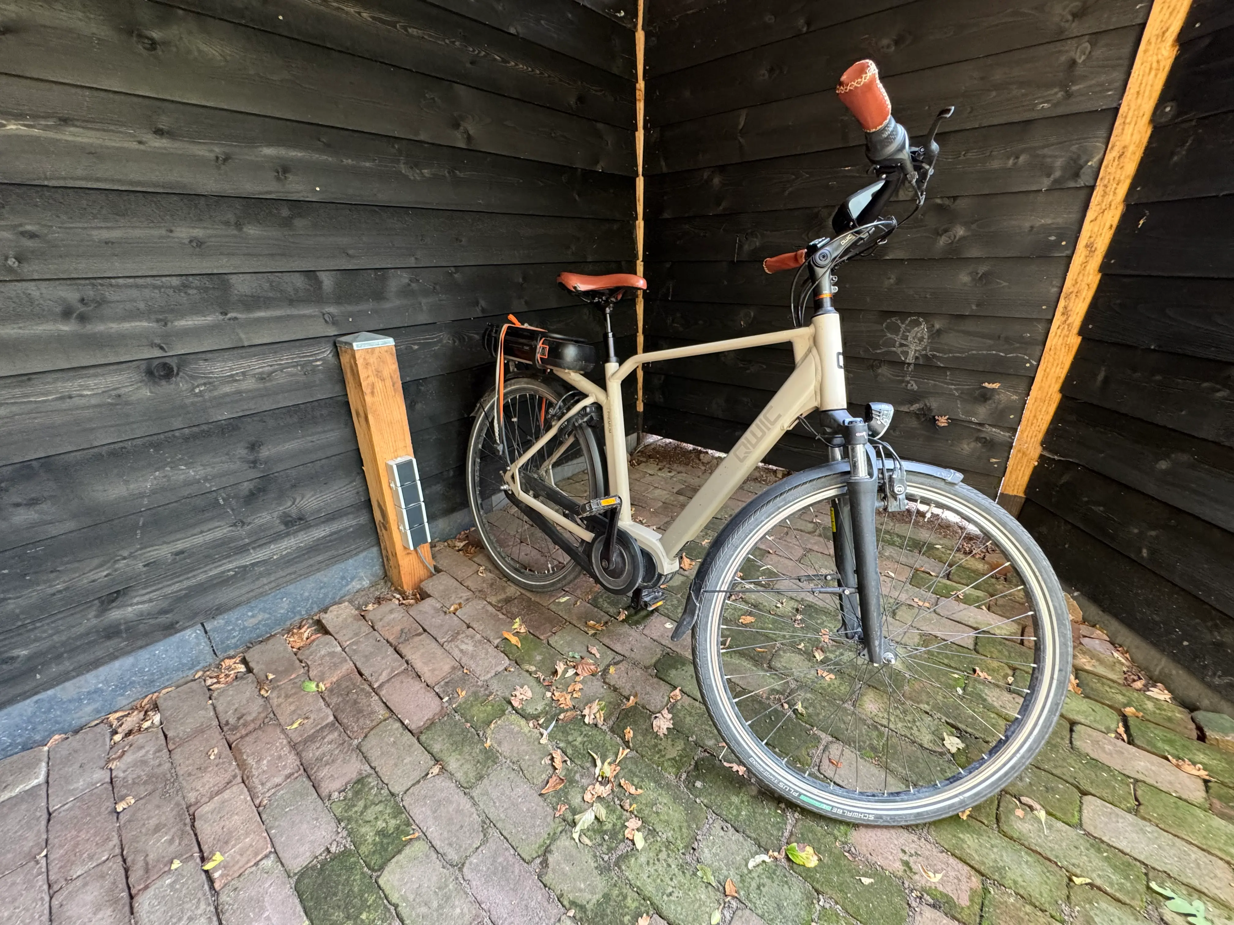 Elektrische fiets in overdekte fietsenstalling met oplaadpunt.