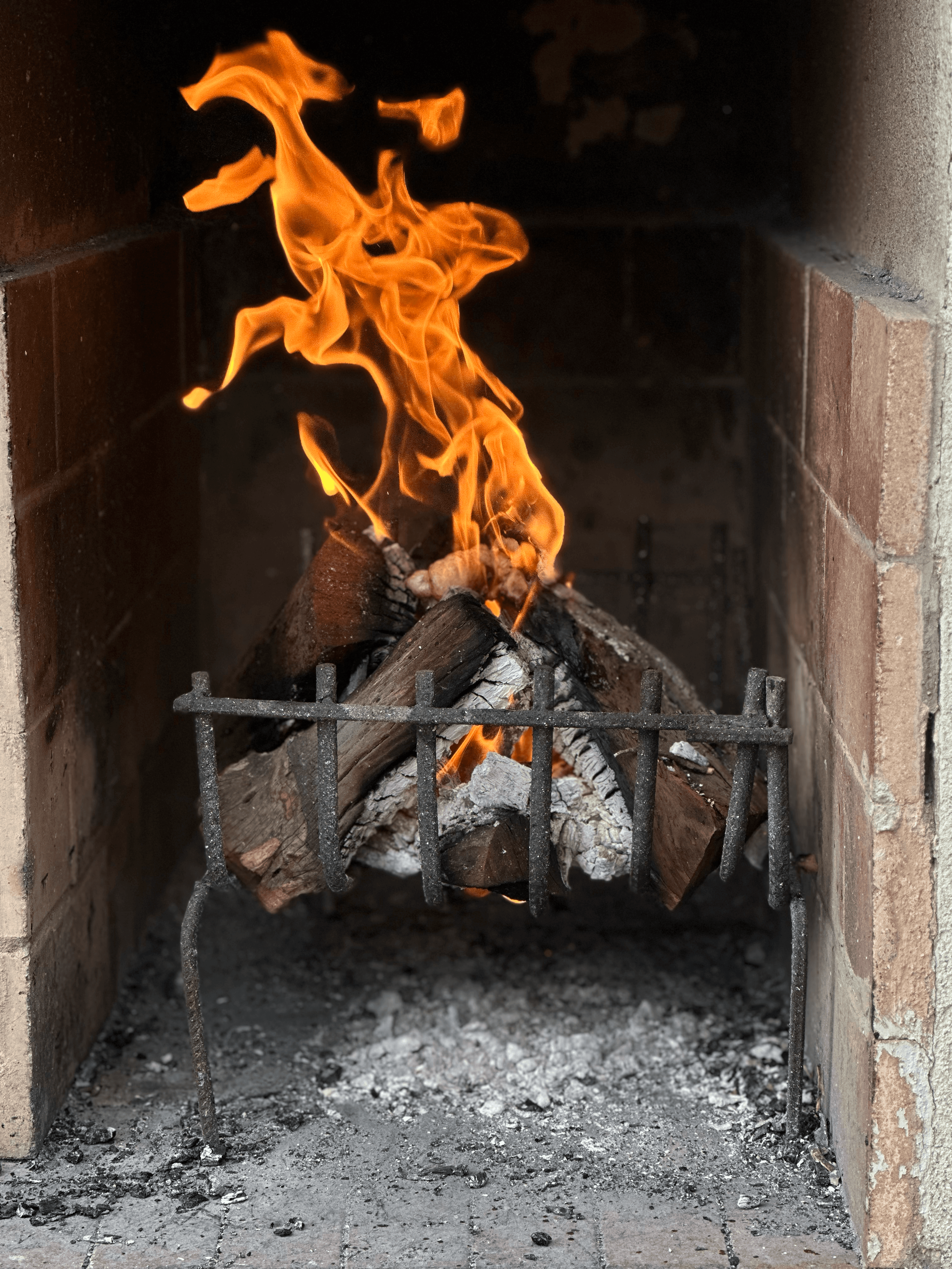Overhead shot of 2 pizzas and a glass of red wine