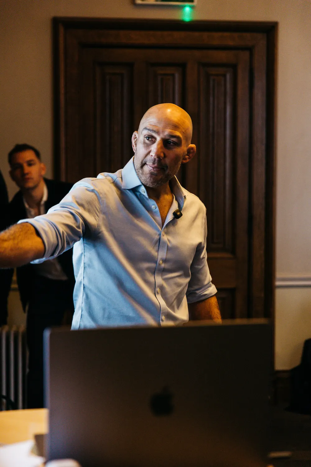 A person leaning against a laptop in an office.