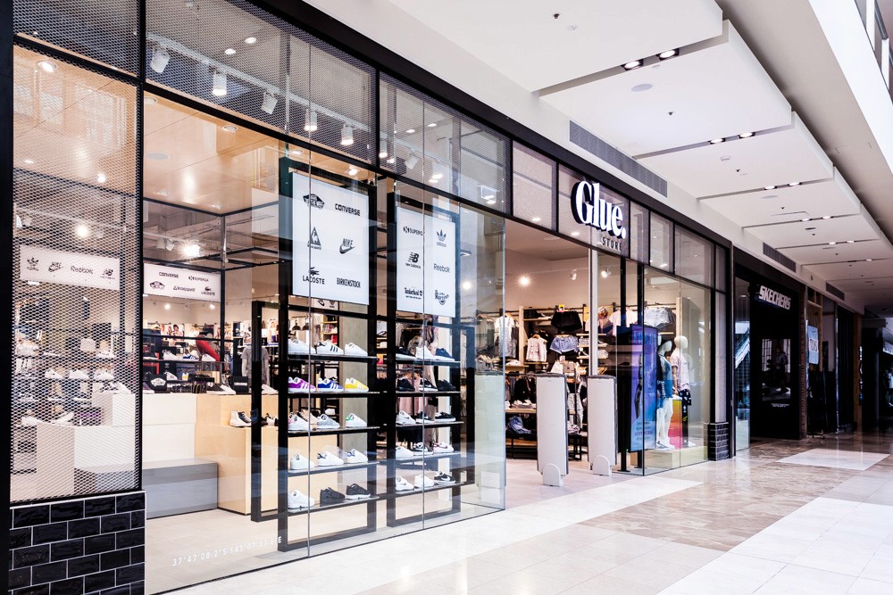 A lady sitting beside her parked bicycle in front of the water