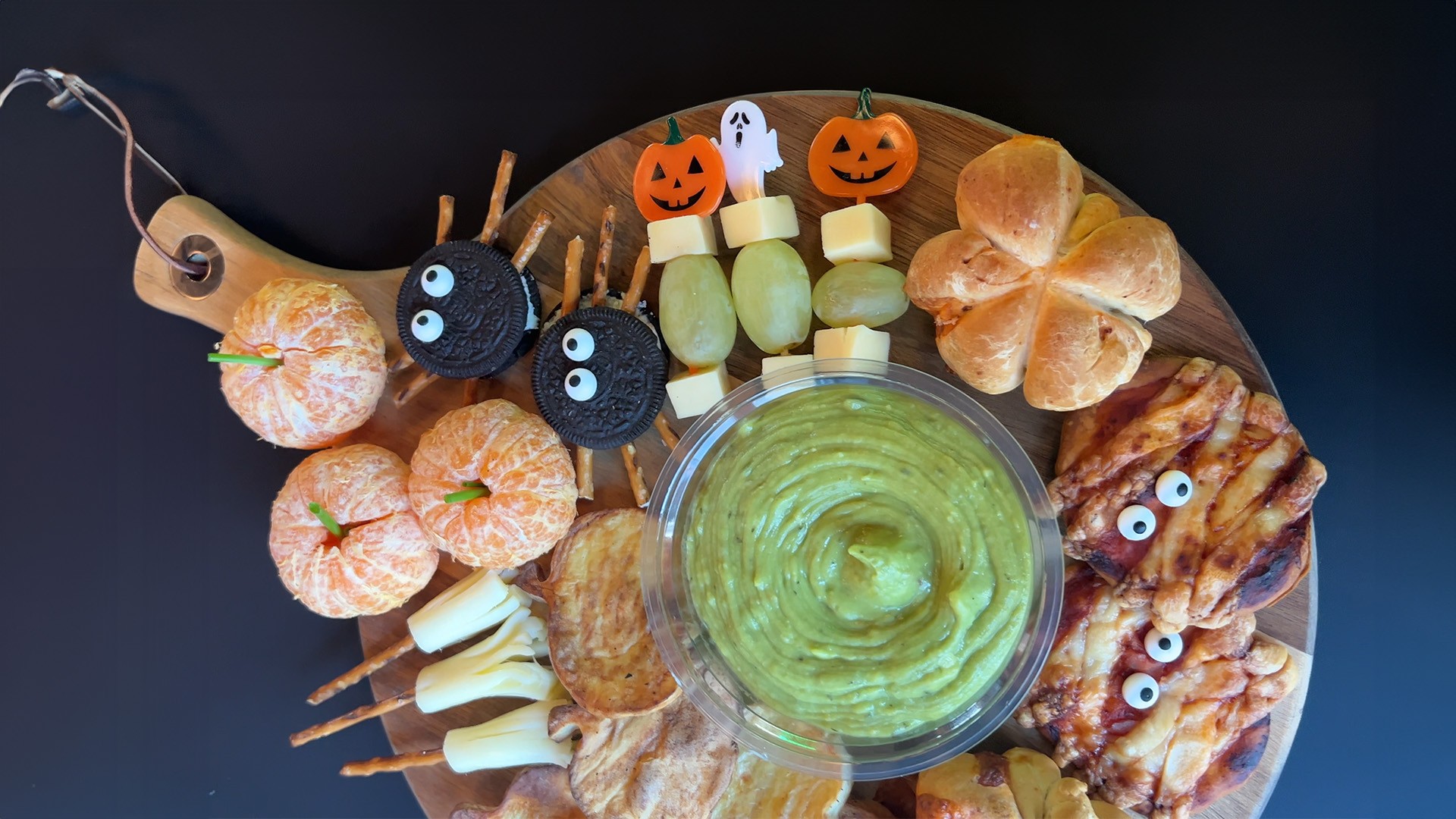 Halloween-Snackplatte mit Oreo-Spinnen, Mandarinen-Kürbissen und Guacamole-Dip