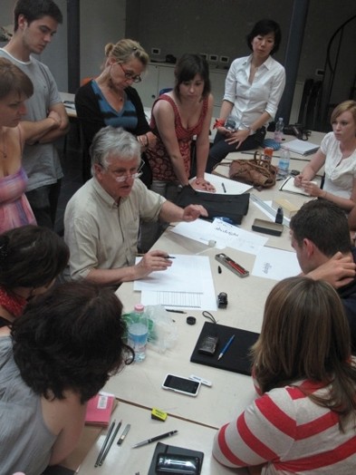 A teacher explaining to the students how to draw letters.