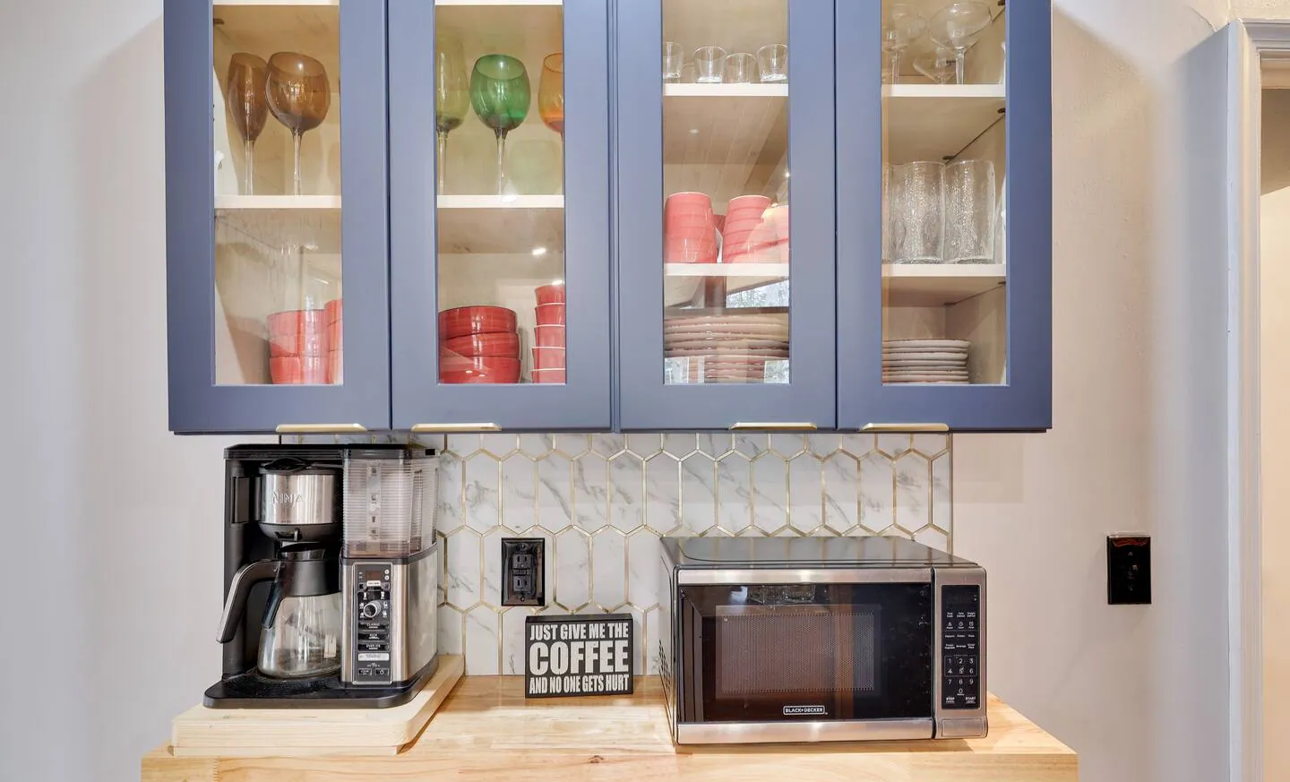 Coffee station with glass-front cabinets, coffee maker and microwave at The Love Shack