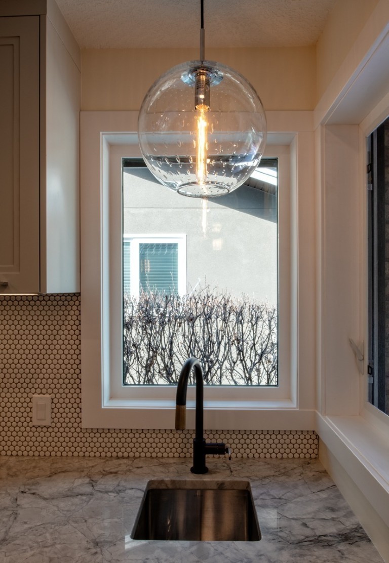 Image of Modern kitchen design with marble countertop, pendant light, and KHD Homes expert interior design and construction.