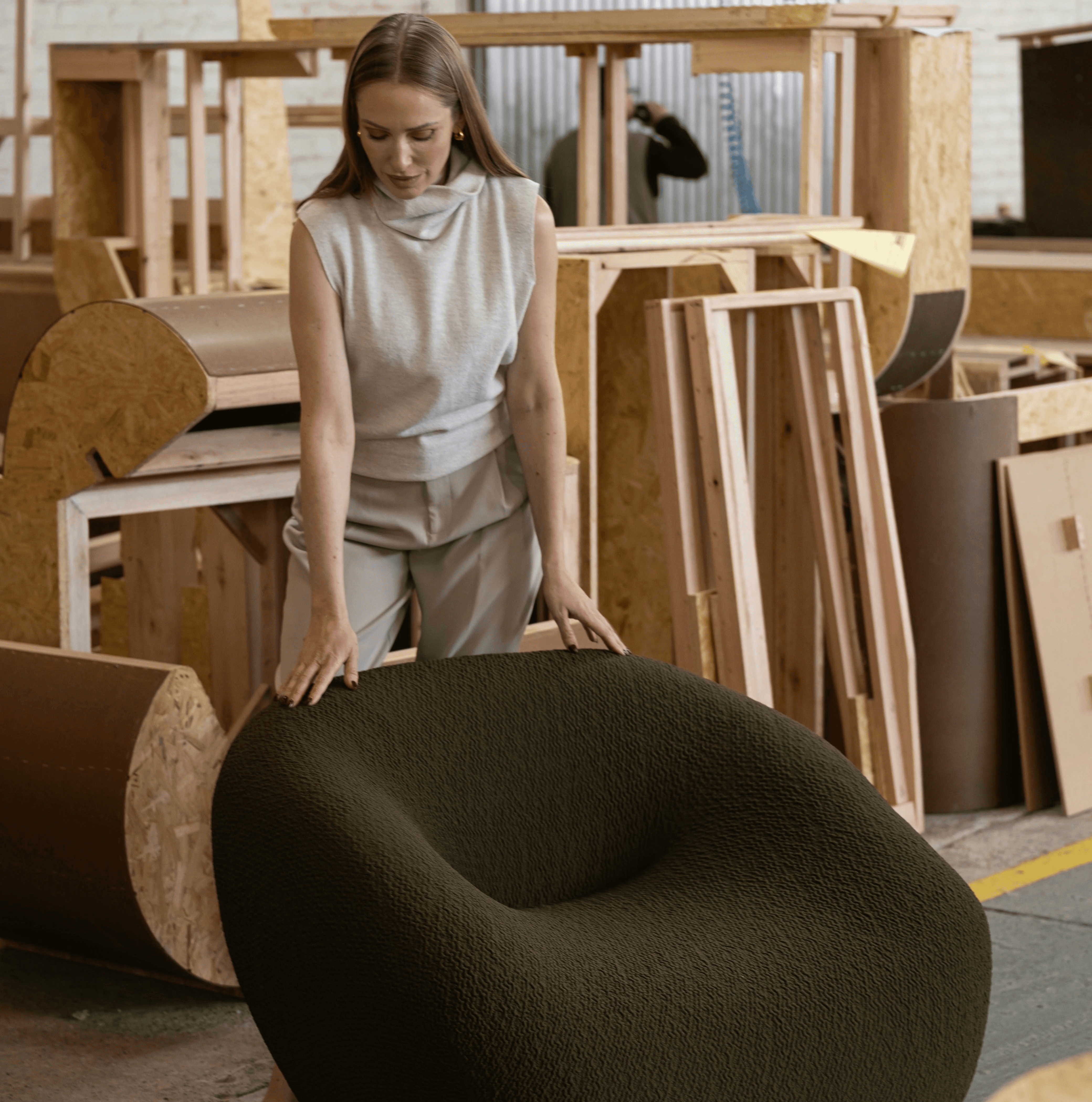 Woman standing by a unique olive green armchair