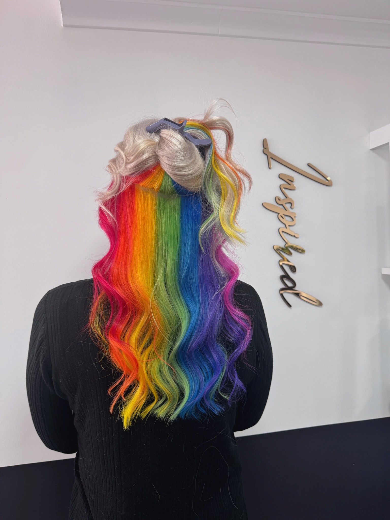 Woman smiling with long black wavy hair in the Inspire Studio Hair Salon