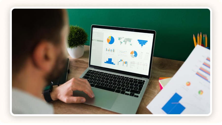 Personne analysant des données marketing sur ordinateur avec graphiques.