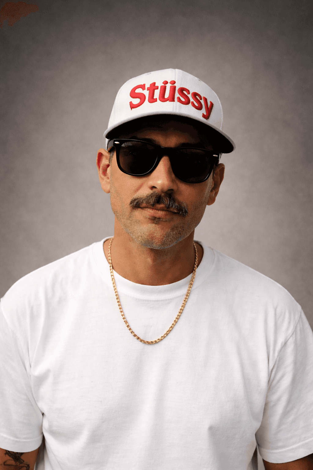 a man on glasses white top and cap