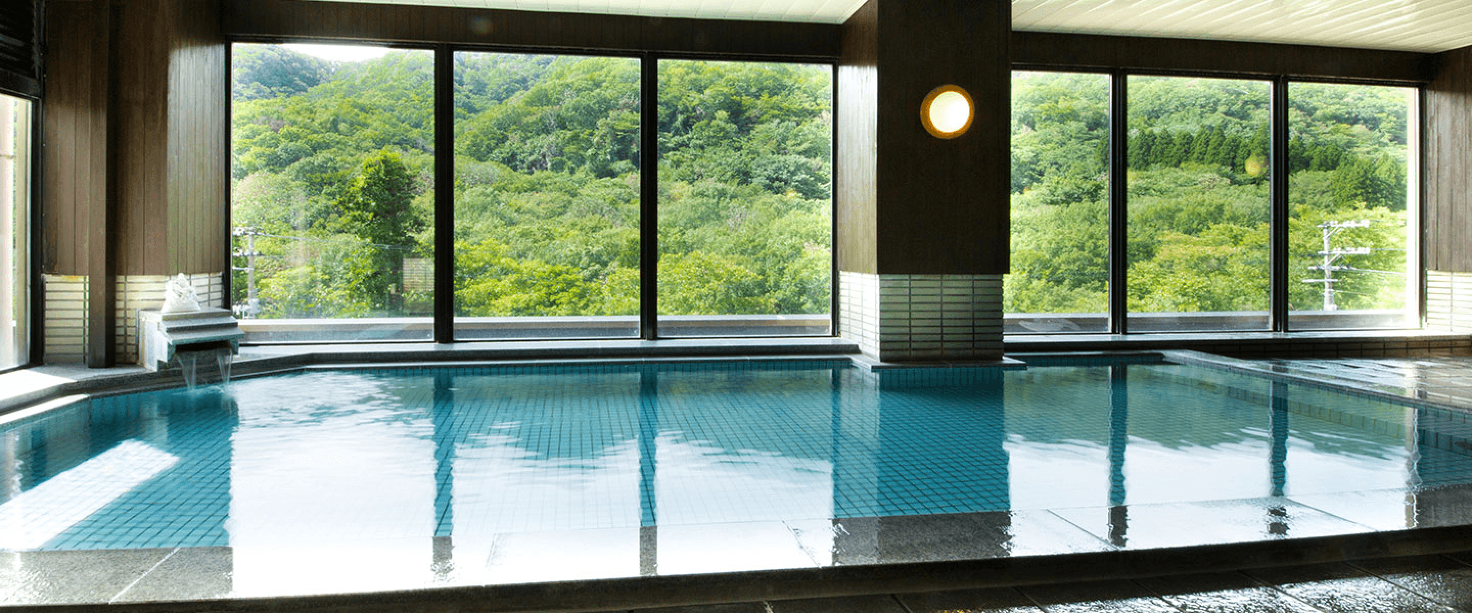 Indoor bath with multiple windows overlooking mountains