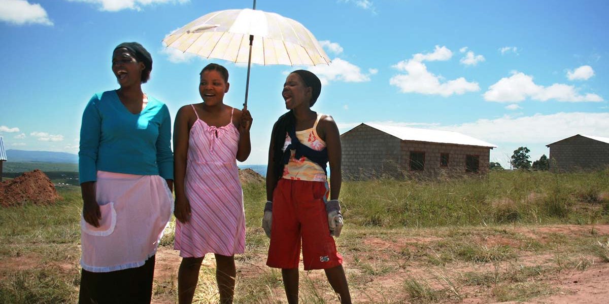 Three children jumping in burlap sacks during a race.