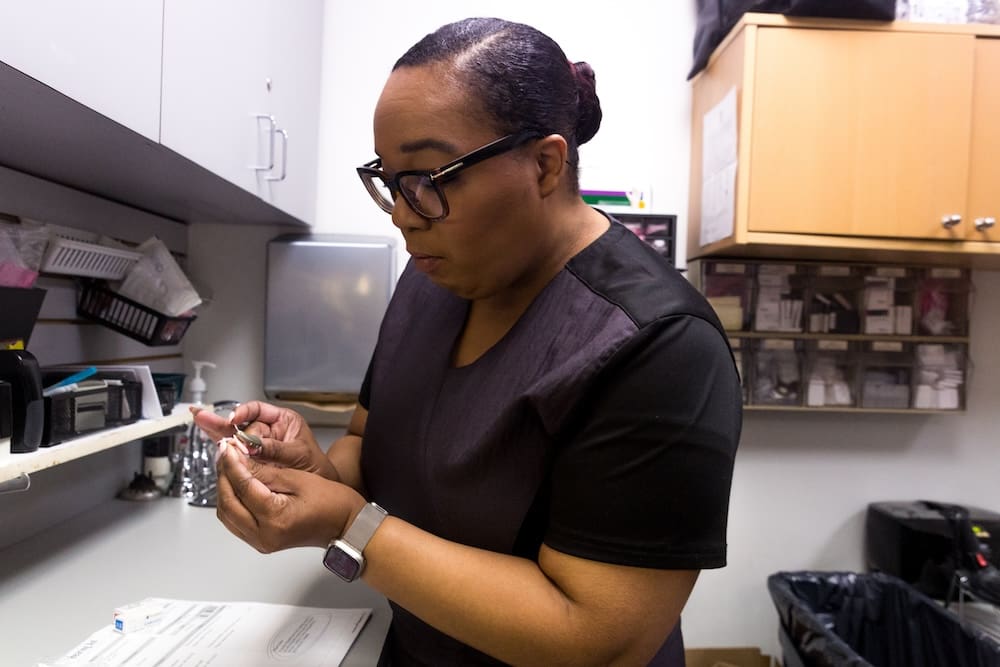 Modern reception area with a blue accent wall, glass desk, and a clock on the wall.