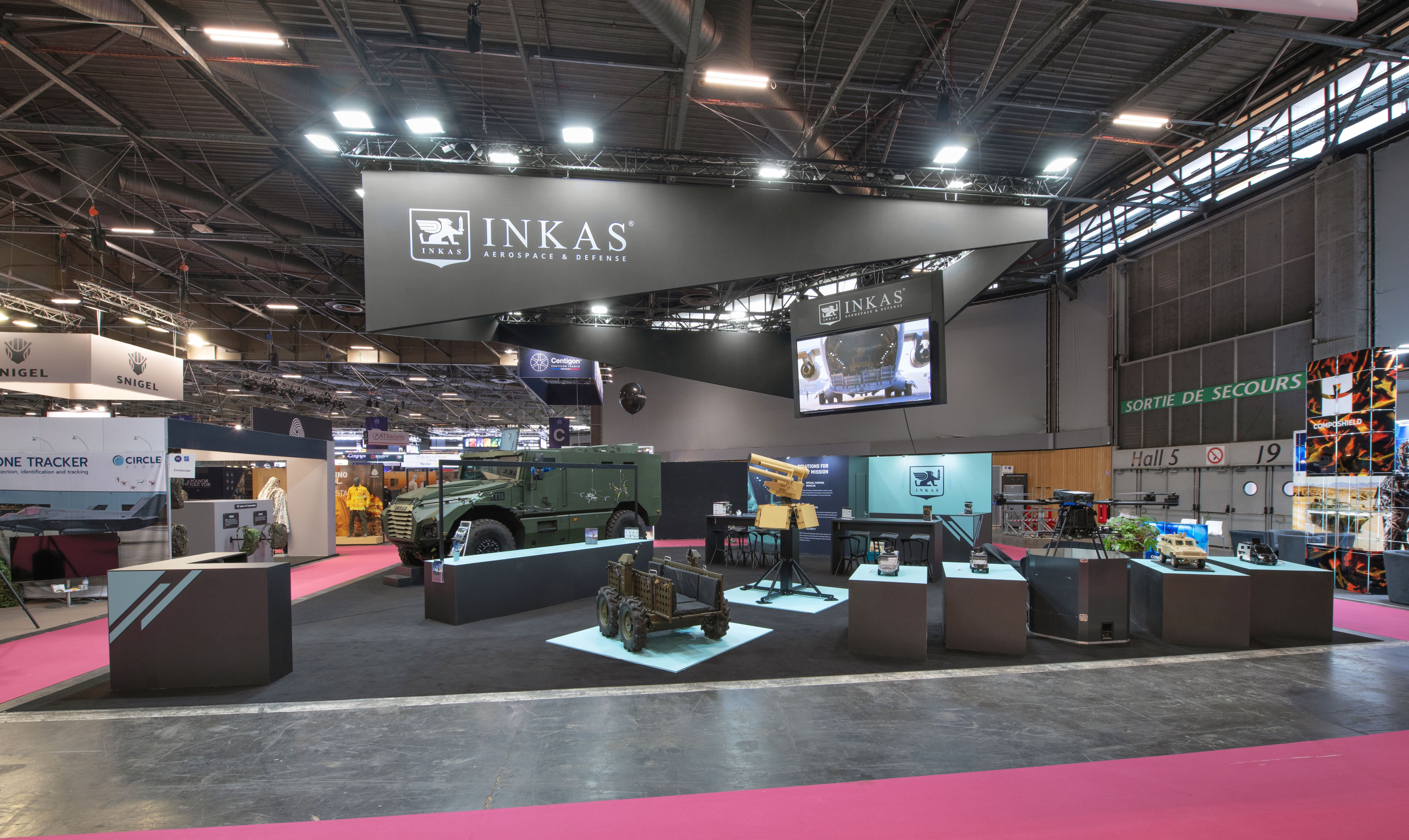 Stand INKAS Milipol Paris 2025 – vue frontale du stand avec véhicules exposés sur podiums, conception Expace