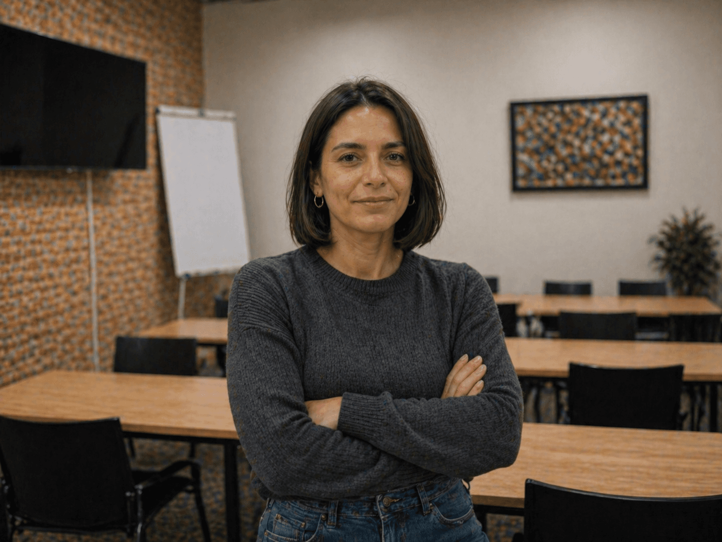 Dos mujeres jóvenes estudiando juntas en una mesa iluminada por luz natural. Una de ellas escribe mientras la otra observa con atención, creando un ambiente de colaboración y aprendizaje.