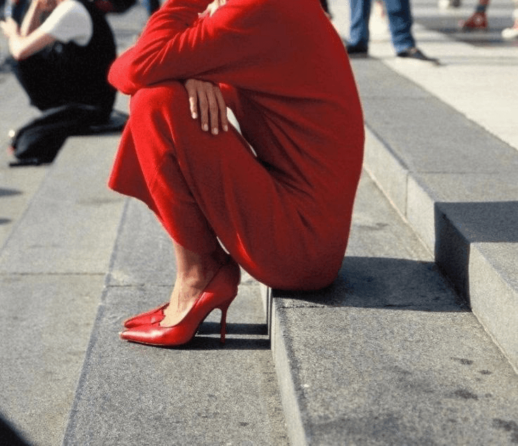 A person stands on a street corner at night.