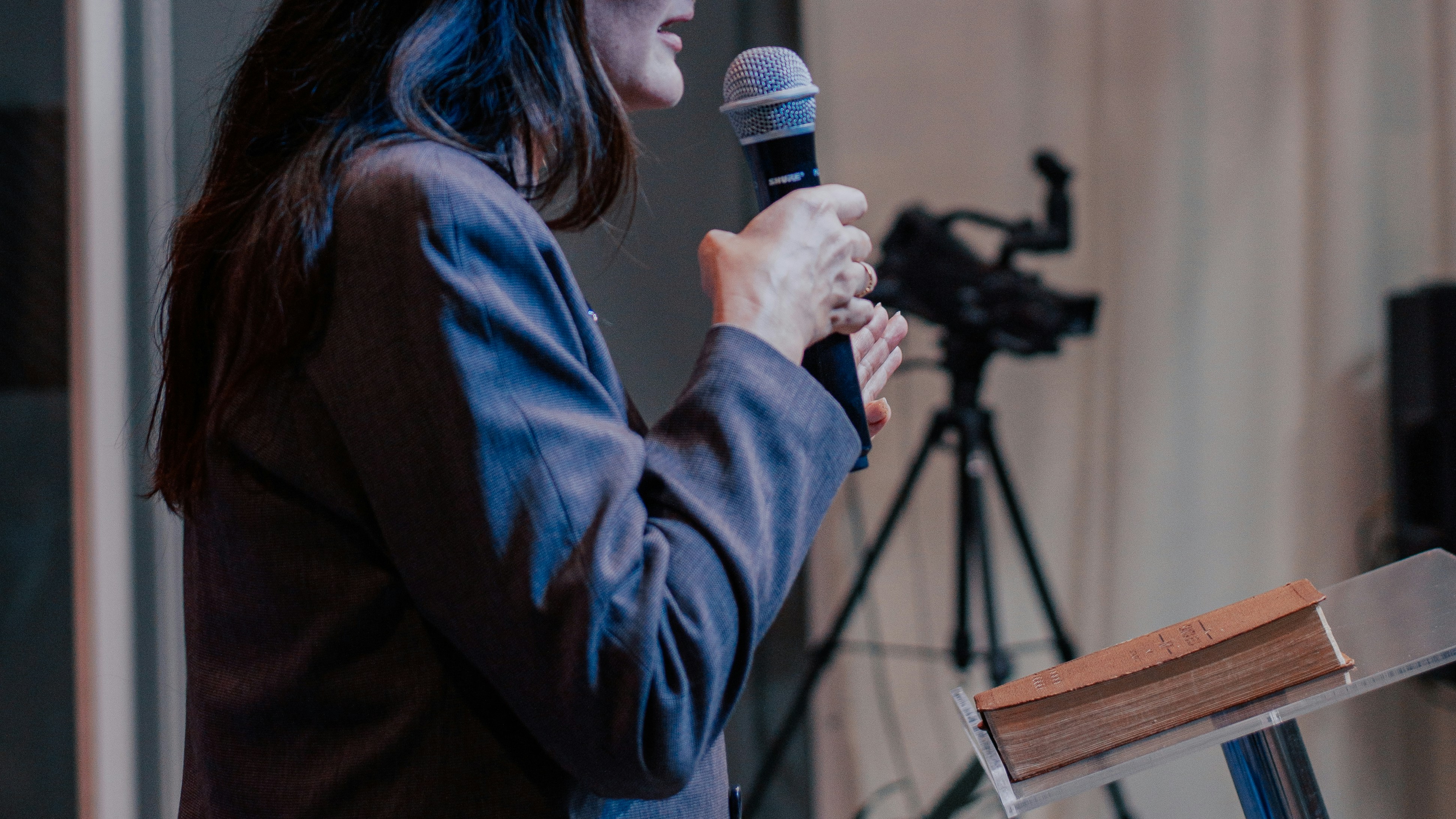 a woman standing at a podium holding a microphone