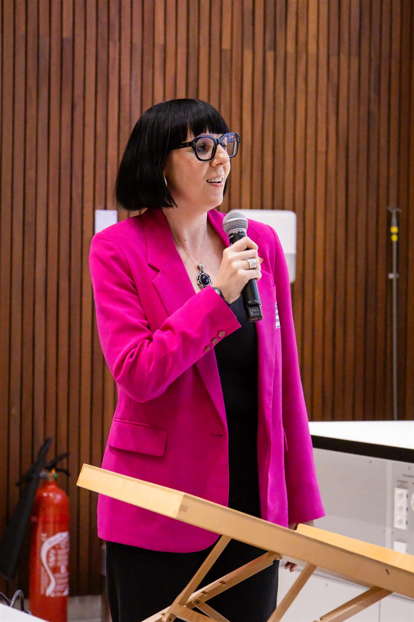 Speaker in pink blazer presenting during EthereumZüri conference in Zurich