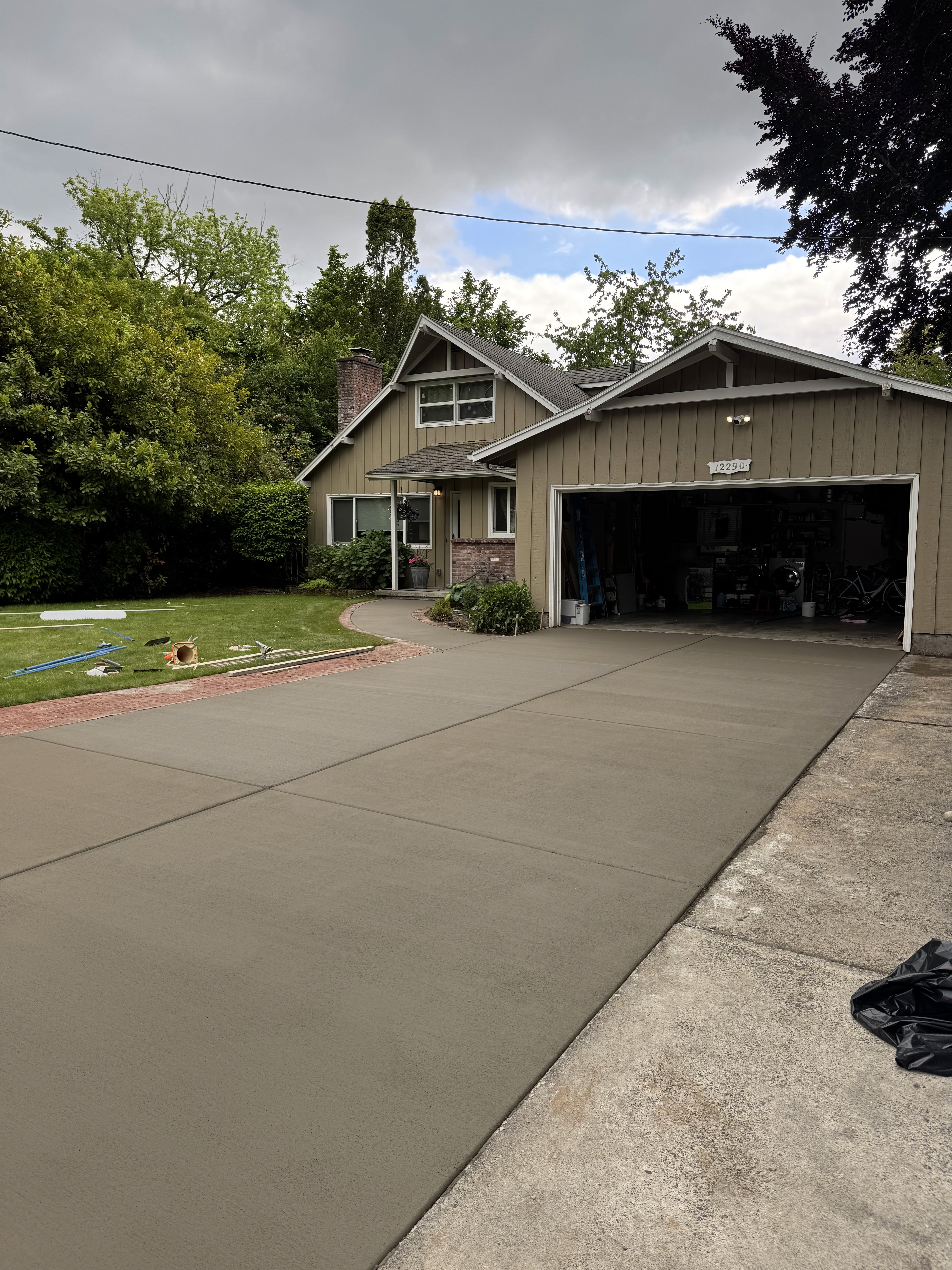 Modern indoor space with large glass doors, lush greenery, and a cozy seating area visible beyond.