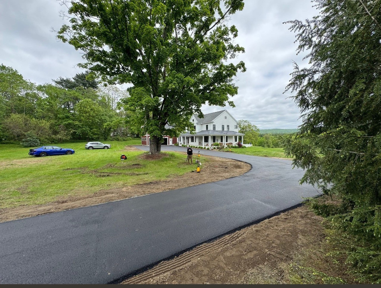 Fresh black driveway under a mature maple, by A&M Construction Enterprises