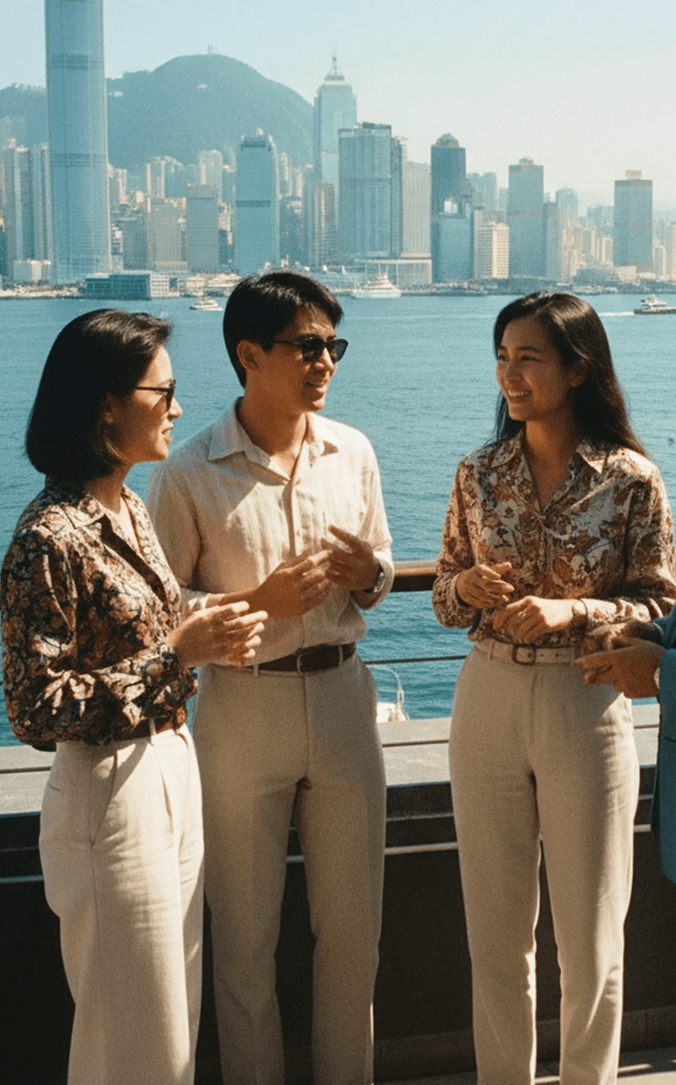 Professionals in classy summer attire networking during the Genesis Festival on a boat deck with the Hong Kong skyline