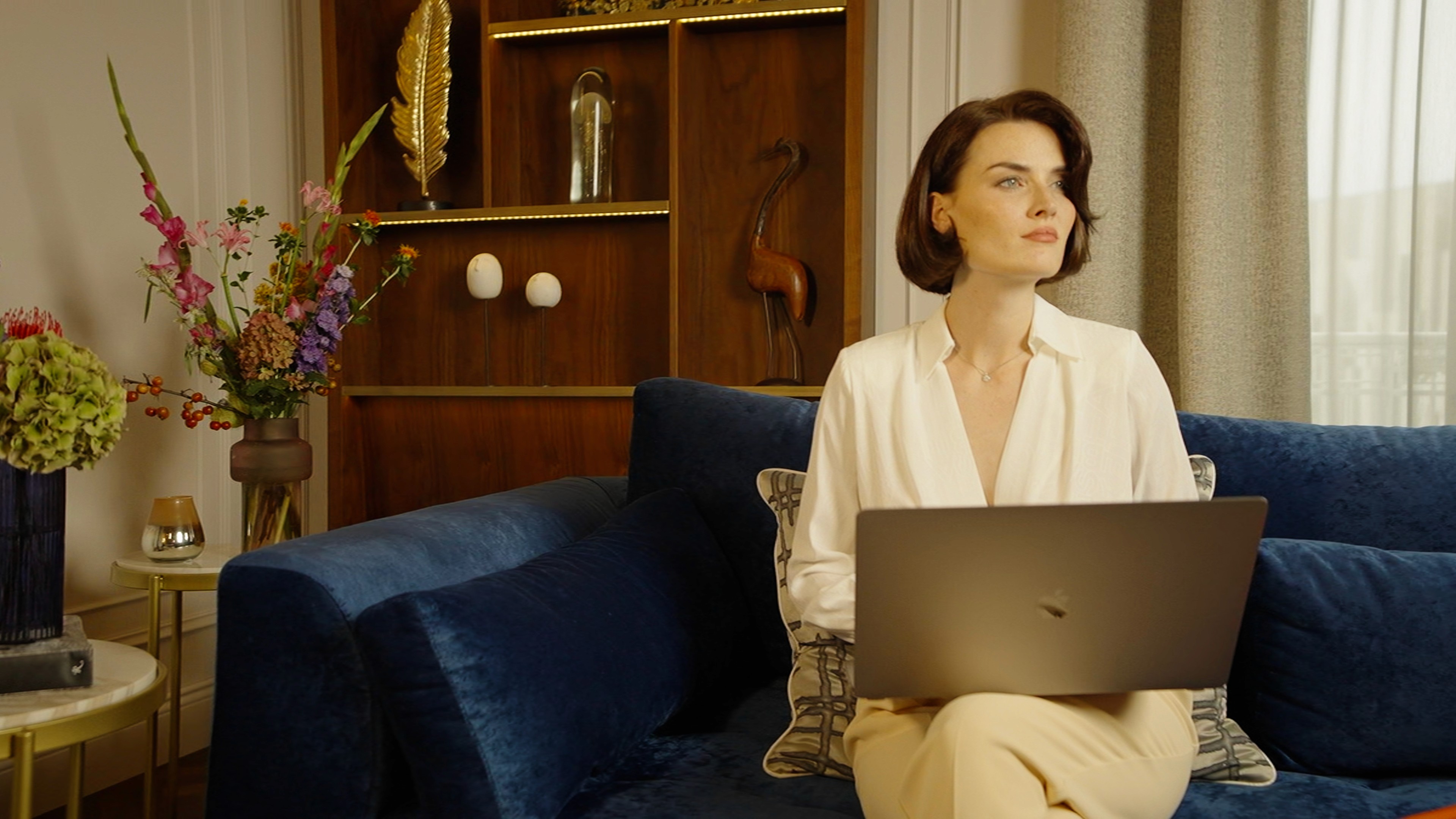 Model sitting on a couch in a luxiurious room