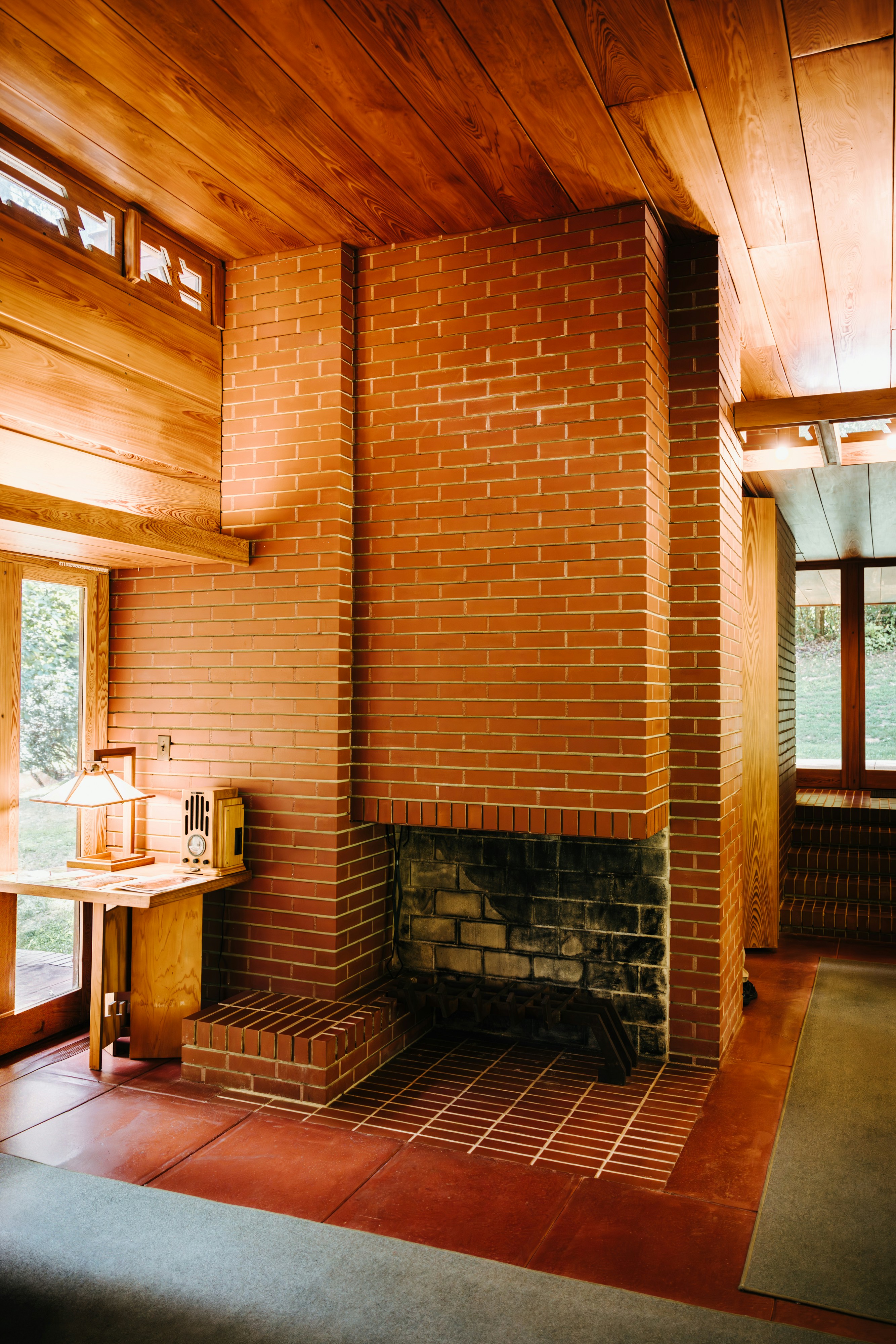 A living room with a brick fireplace and a large window