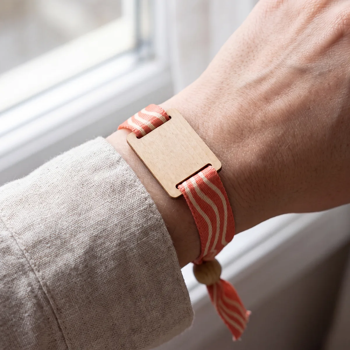 Woven fabric wristband with wooden closure, worn on the wrist