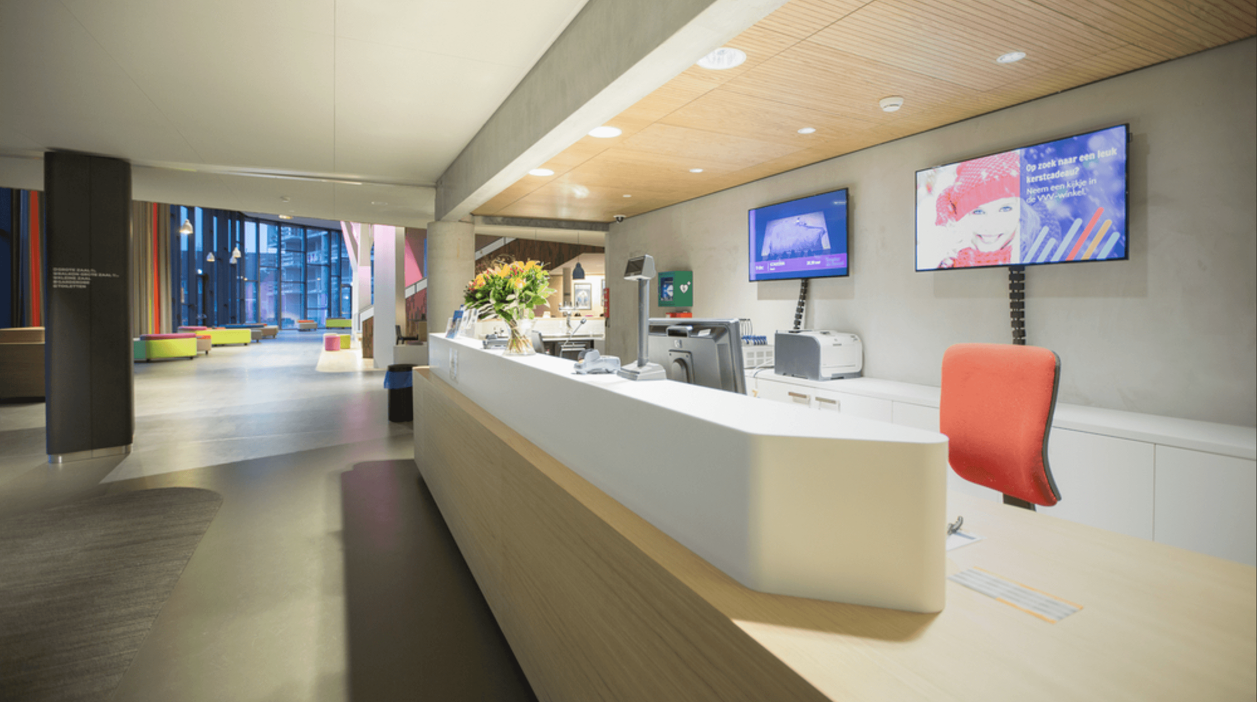 Reception area digital signage screens in a modern lobby displaying announcements and visitor information for enhanced communication.