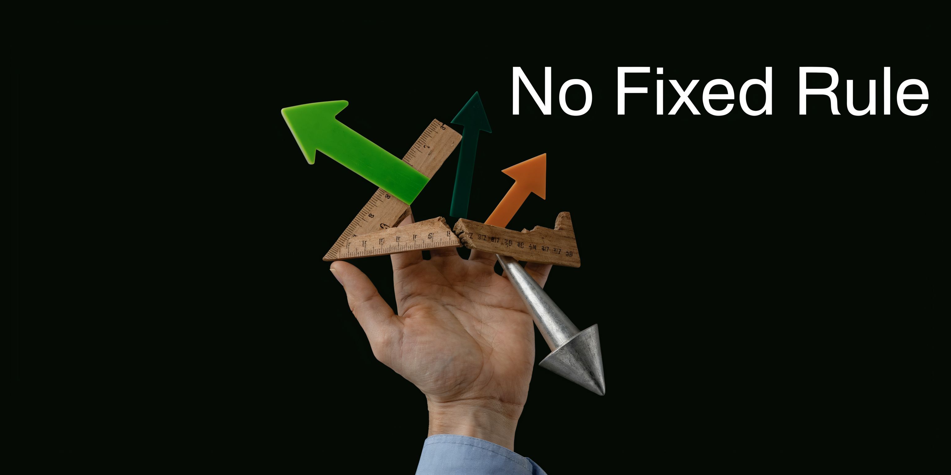 A hand balances broken wooden rulers and colorful arrows representing unpredictable paths against a black background.