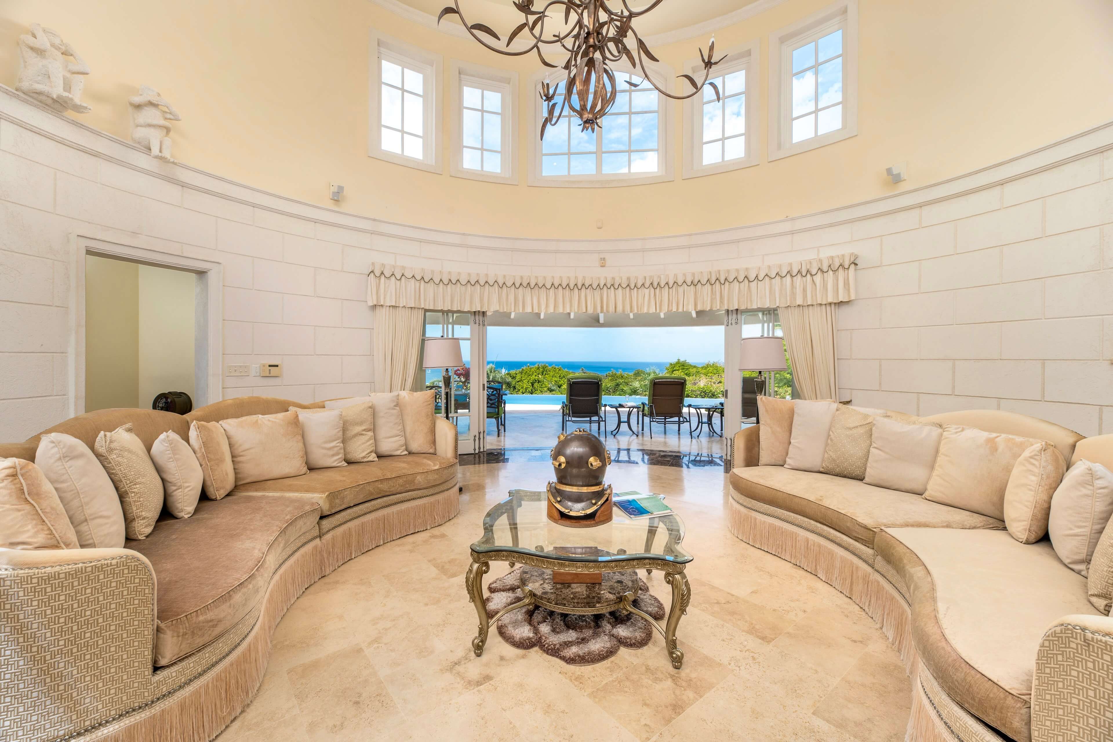 Elegant living room with curved sofas and a view of the terrace