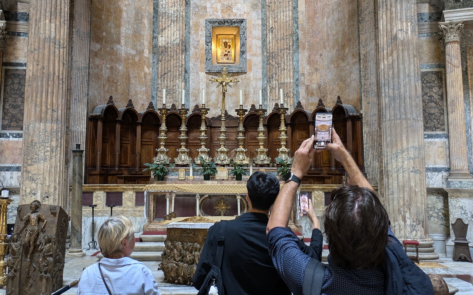 Visitantes fotografando o altar dentro do Panteão em Roma.