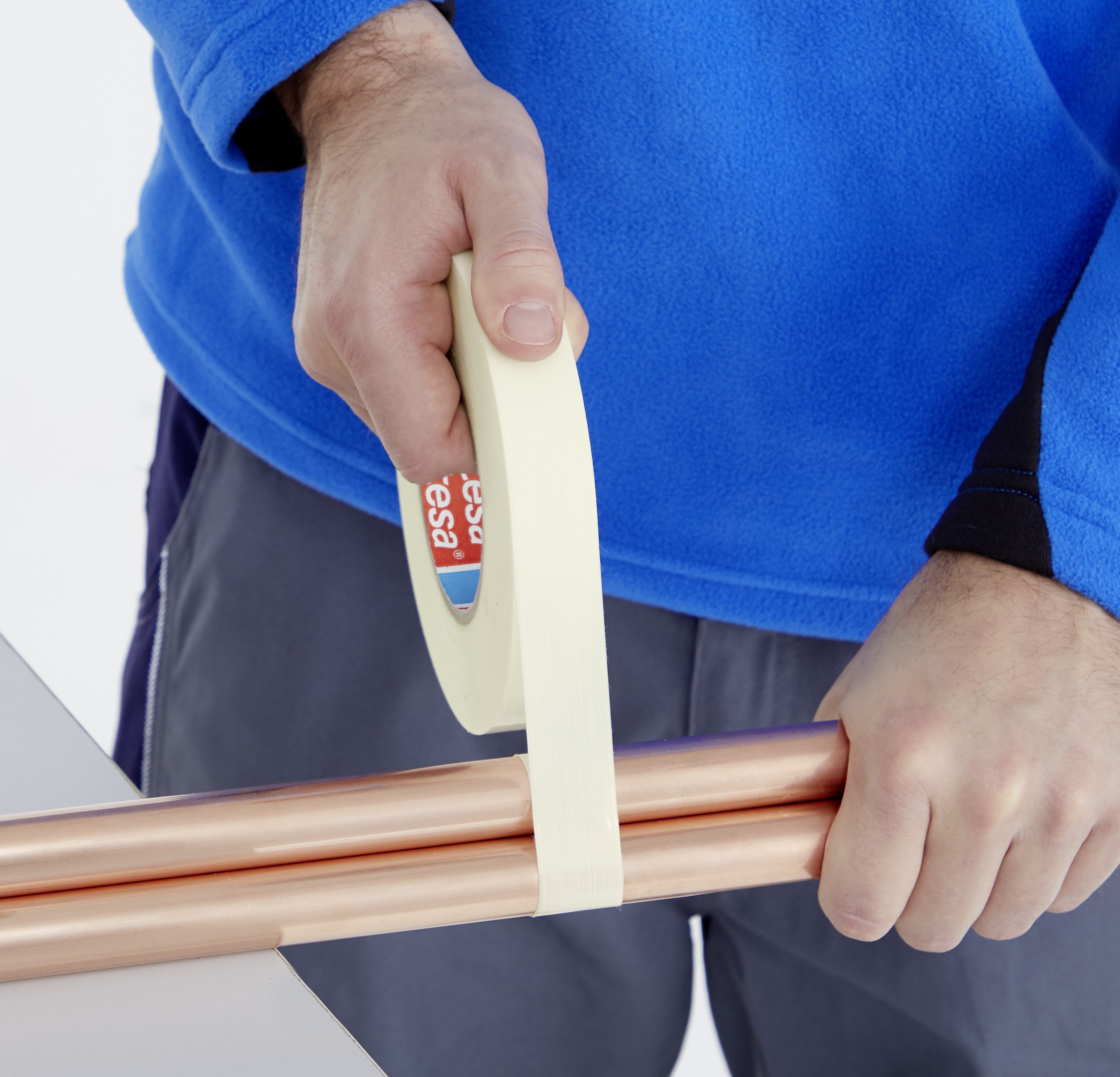 tesa 4311 Abdeckband auf Basis eines Fein-Krepp-Papierträger klebt drei Metallrohre zusammen