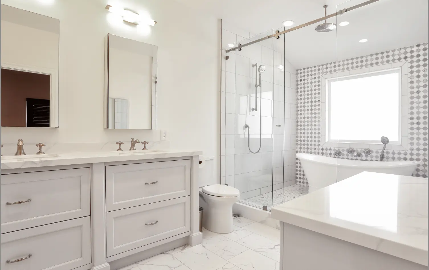 Primary bathroom with muted tones, double vanity, makeup vanity, and spacious walk-in shower and marble tile. Photo by Chris Darnall.