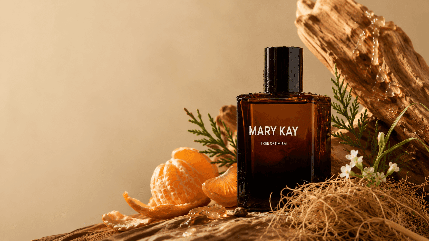 Frasco True Optimism™ Deo Parfum Mary Kay em composição editorial com mandarina, cipreste, flores brancas, raízes de vetiver e madeira.