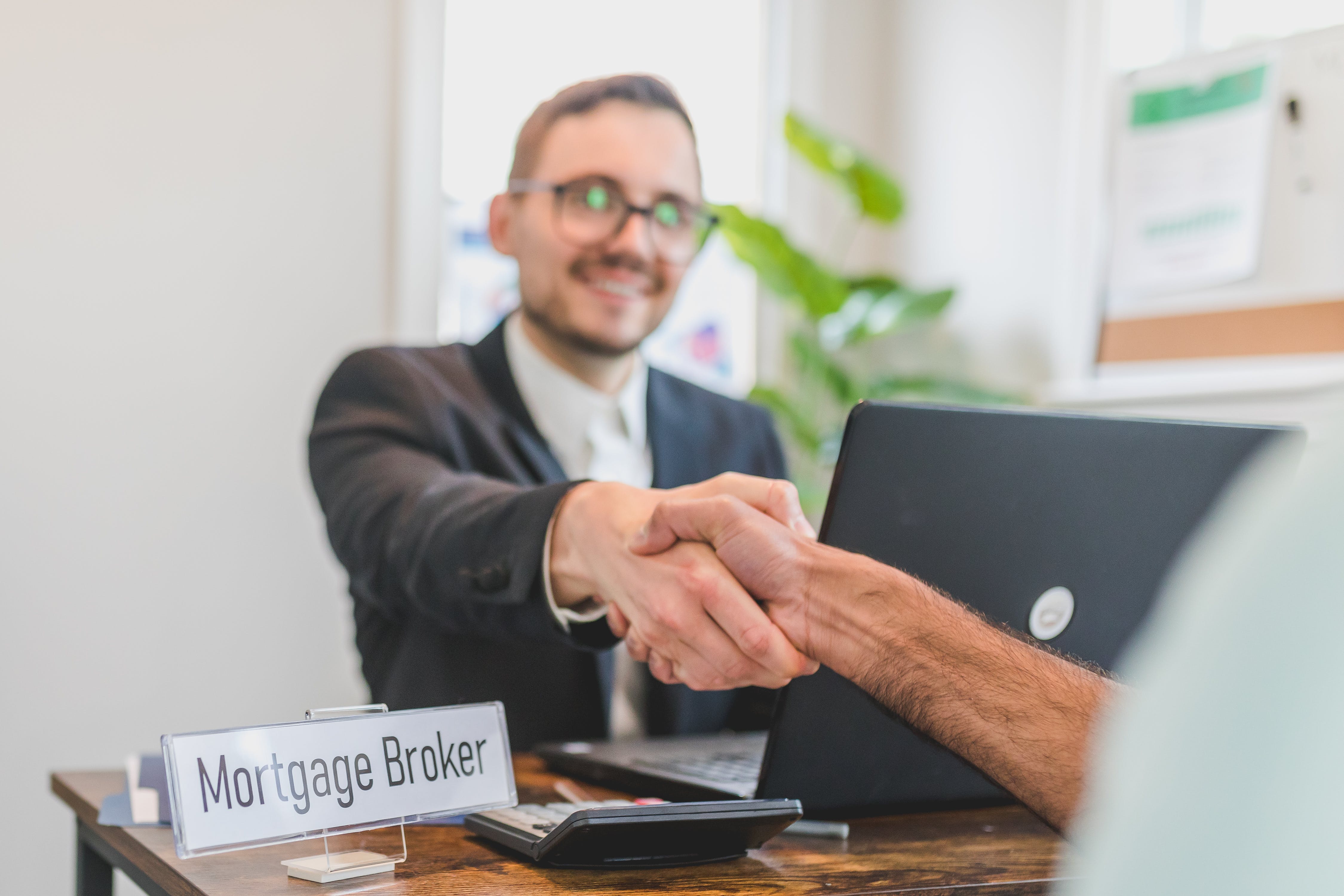 A mortgage broker shaking hands with his new client