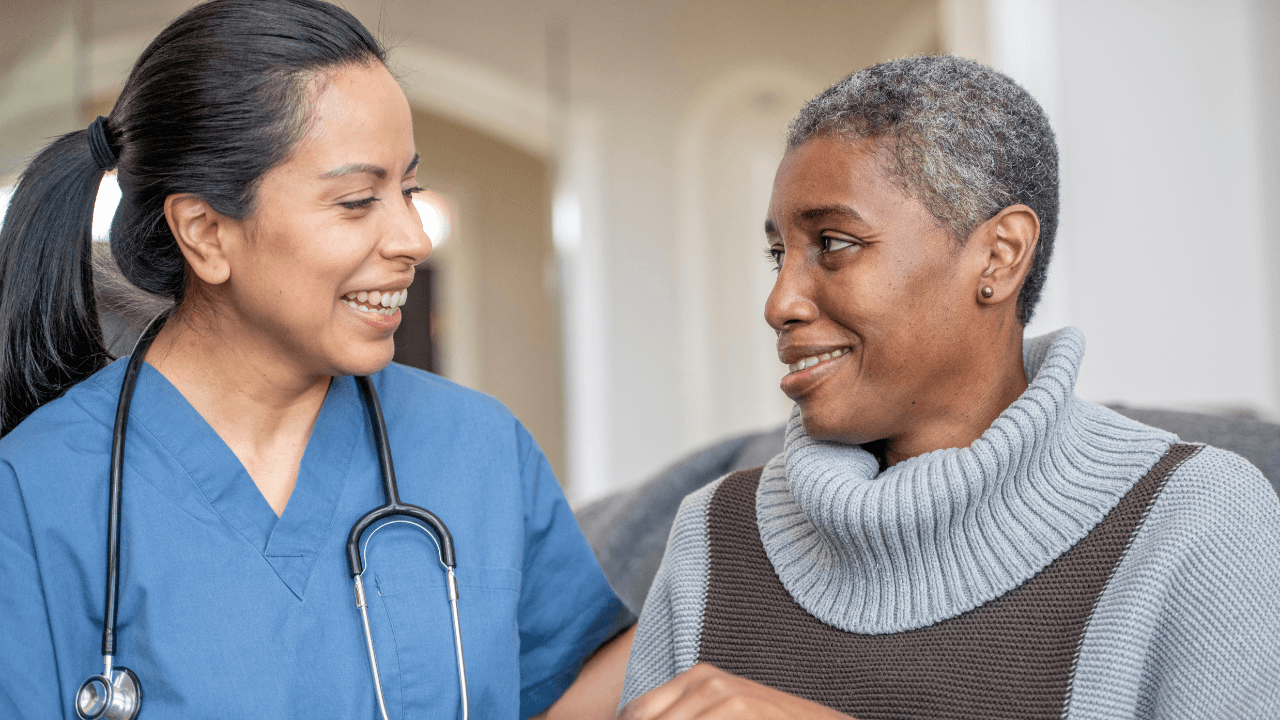 A nurse smiling at an elderly woman