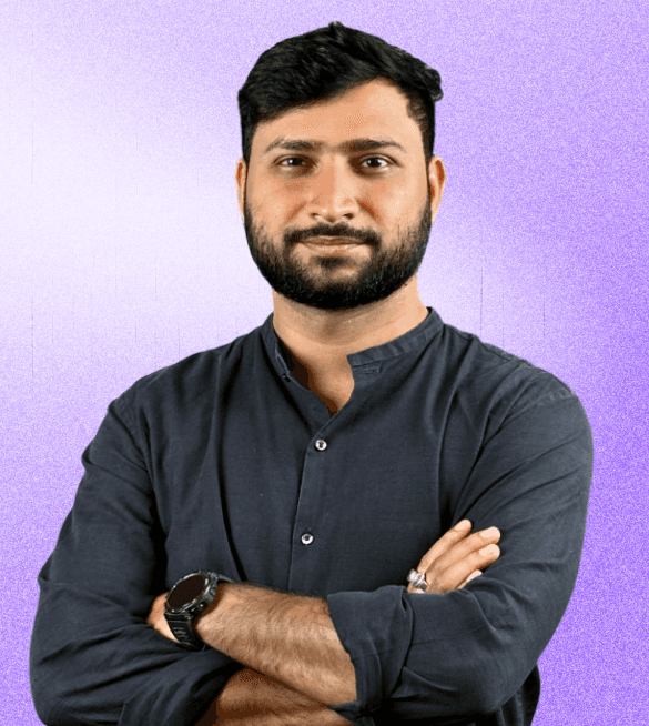 Portrait of Neeraj, wearing a dark-colored kurta with arms crossed, looking confident against a light purple gradient background.