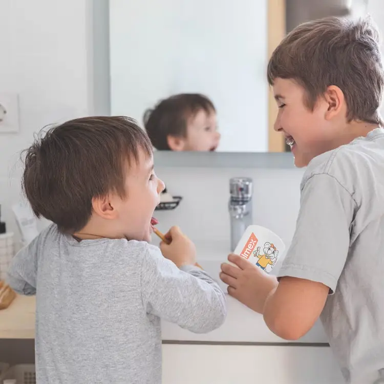 enfants se brossant les dents avec le dentifrice Elmex, marque proposée pa la pharmacie d'Ecquevilly