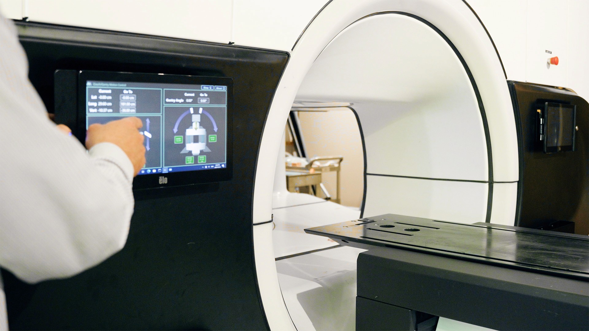 a man presses a button to rotate a MRI machine