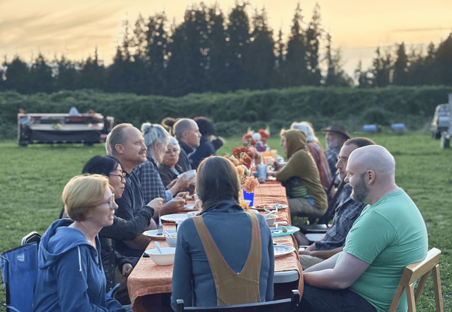 A shared outdoor meal where neighbors connect over food and conversation.